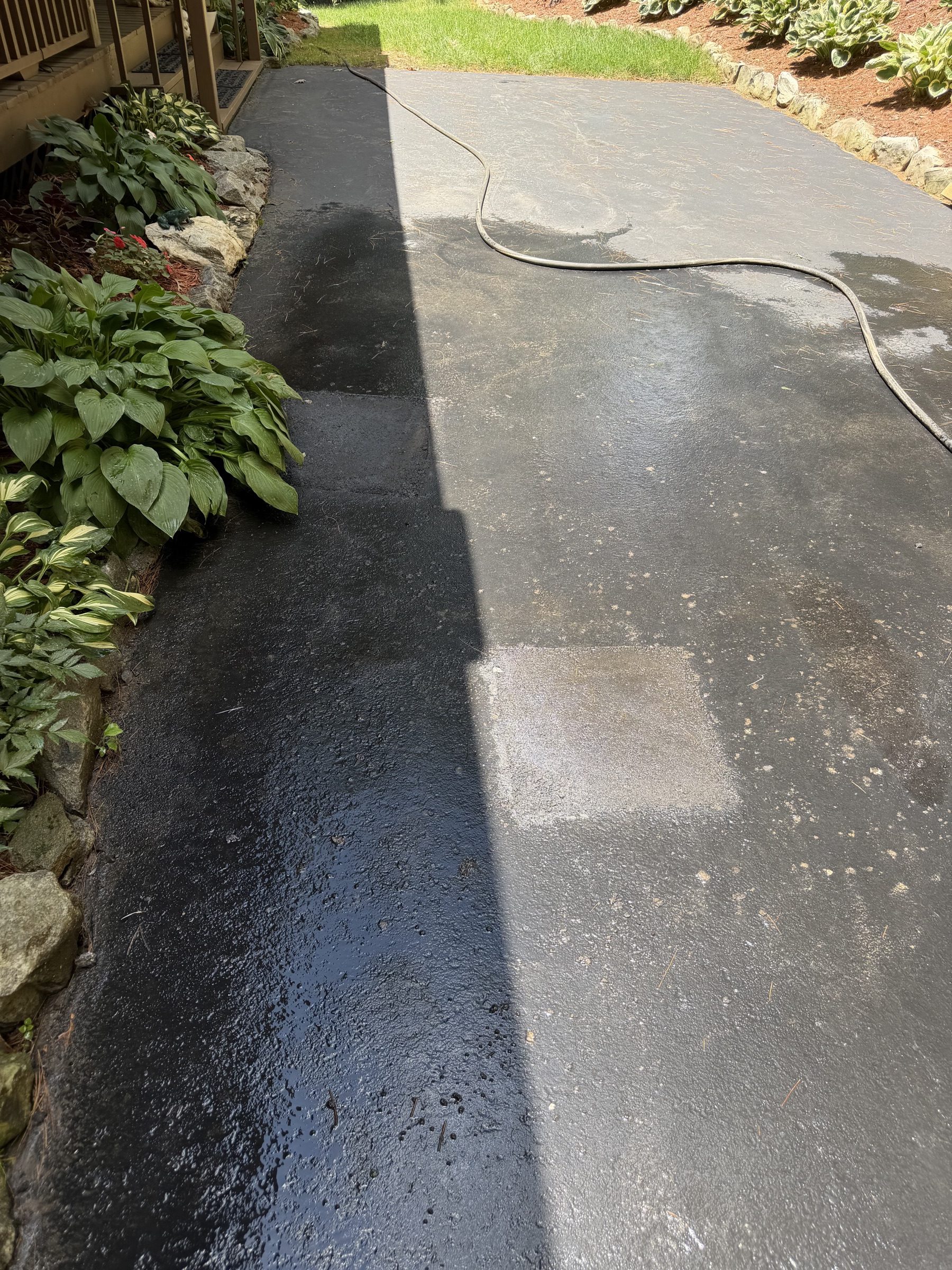 Localized asphalt driveway patch on a wet surface
